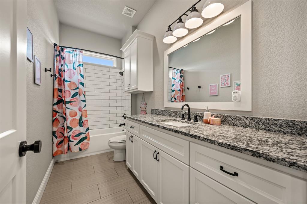 175 County Road 1109 Decatur, TX 76234 - Photo 24 of 39 a bathroom with a granite countertop sink mirror and a toilet
