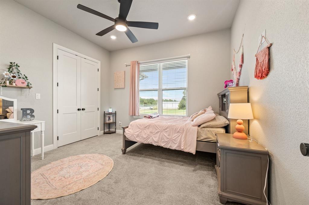 175 County Road 1109 Decatur, TX 76234 - Photo 25 of 39 a spacious bedroom with a bed and a chandelier