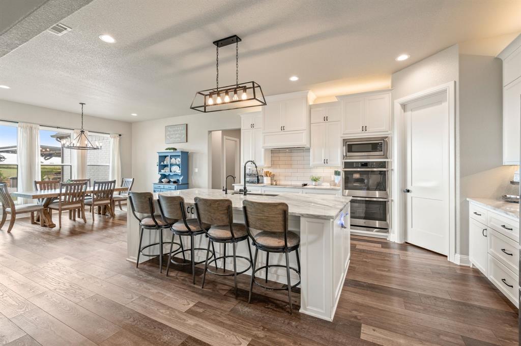 175 County Road 1109 Decatur, TX 76234 - Photo 10 of 39 a kitchen with stainless steel appliances kitchen island granite countertop a table chairs sink and cabinets