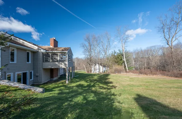 a backyard of a house with table and chairs