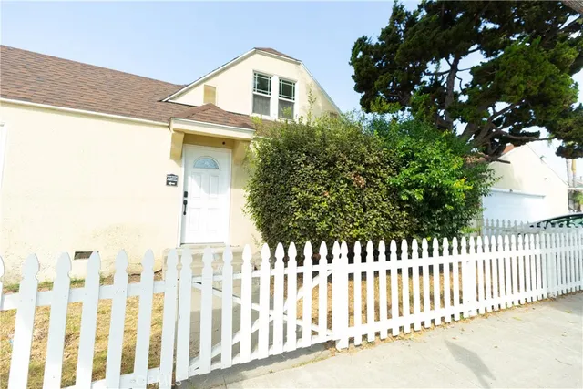 a view of a house with backyard and trees