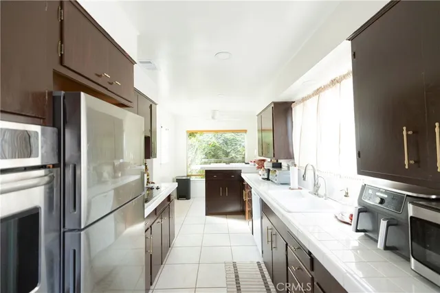 a large kitchen with a large window and stainless steel appliances