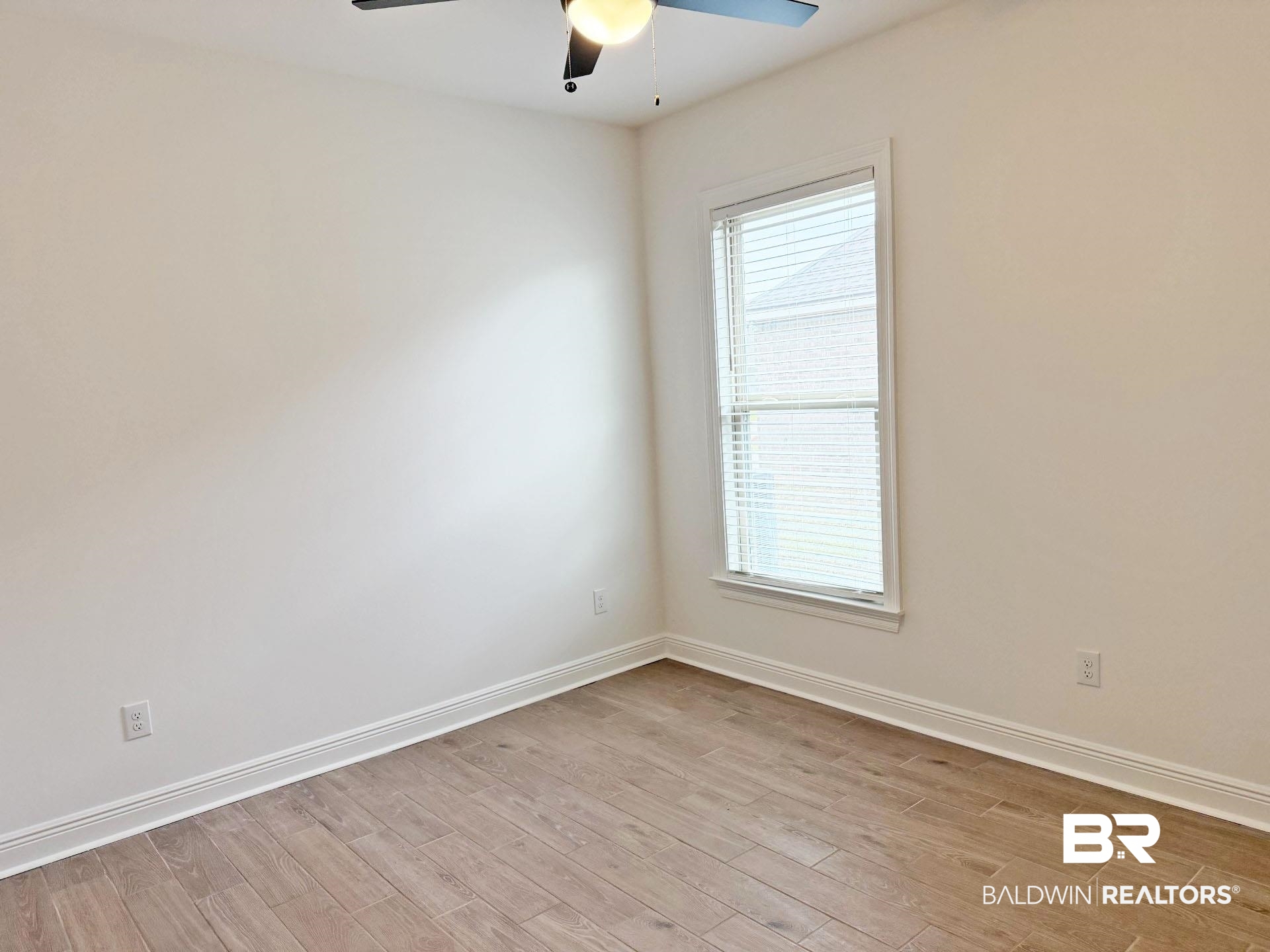1753 Breckinridge Place Foley, AL 36535 - Photo 20 of 24 Bright room featuring wood-finish flooring, white baseboards, and a ceiling fan with integrated lighting