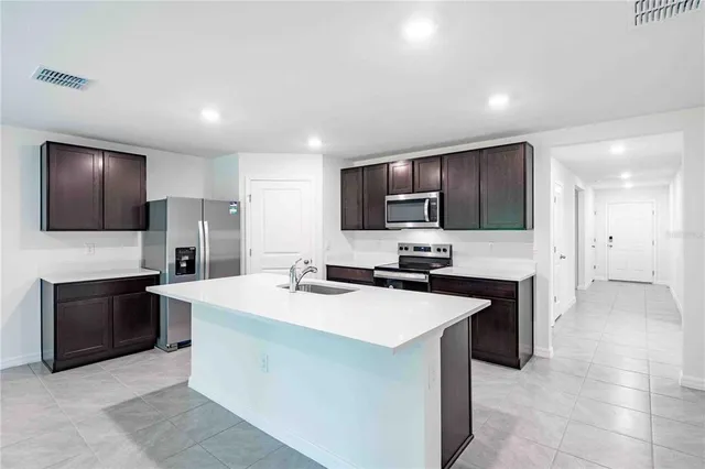 a kitchen with stainless steel appliances a stove sink microwave refrigerator and cabinets