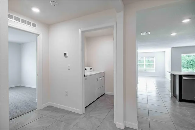 a view of a hallway with bathroom and utility room