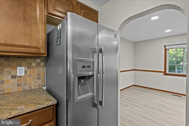 a kitchen with stainless steel appliances granite countertop a refrigerator and a sink