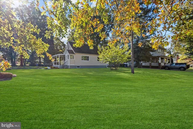 a front view of a house with a garden and trees