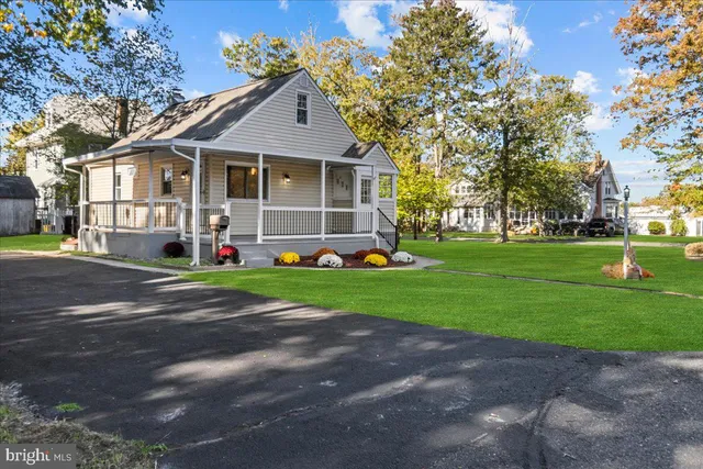 a front view of a house with a yard and trees