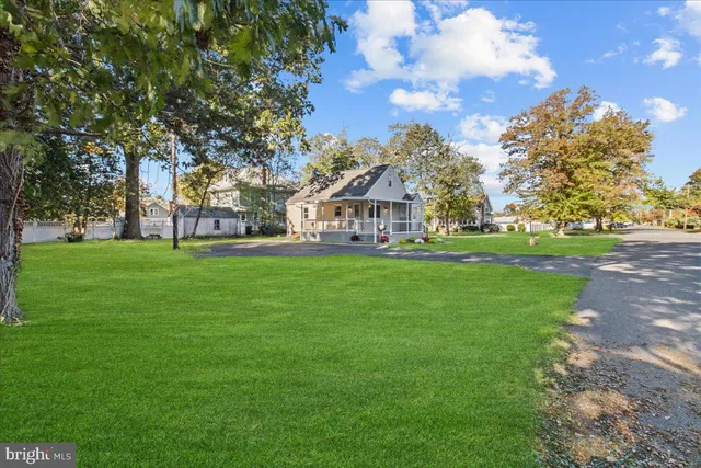 a front view of a house with a yard and trees