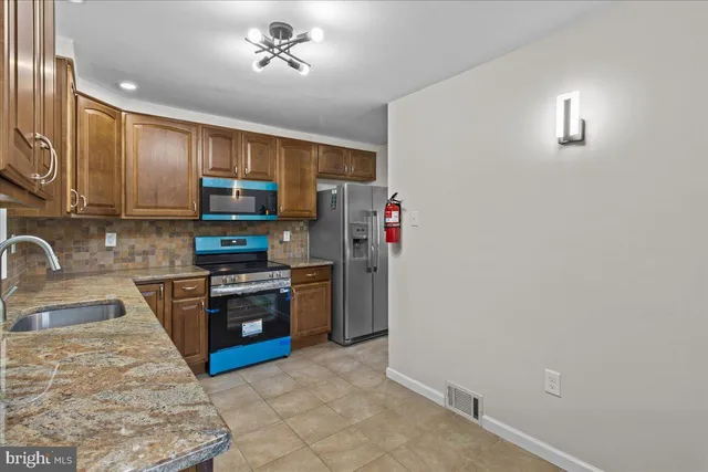 a kitchen with stainless steel appliances granite countertop a stove top oven a sink and dishwasher