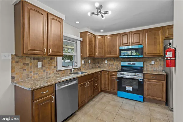 a kitchen with stainless steel appliances granite countertop a stove sink and cabinets