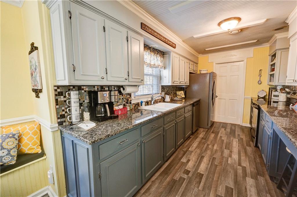 651 Camelot Circle Northwest Calhoun, GA 30701 - Photo 19 of 56 a kitchen with stainless steel appliances granite countertop a stove a refrigerator a sink dishwasher and wooden cabinets with a dining table