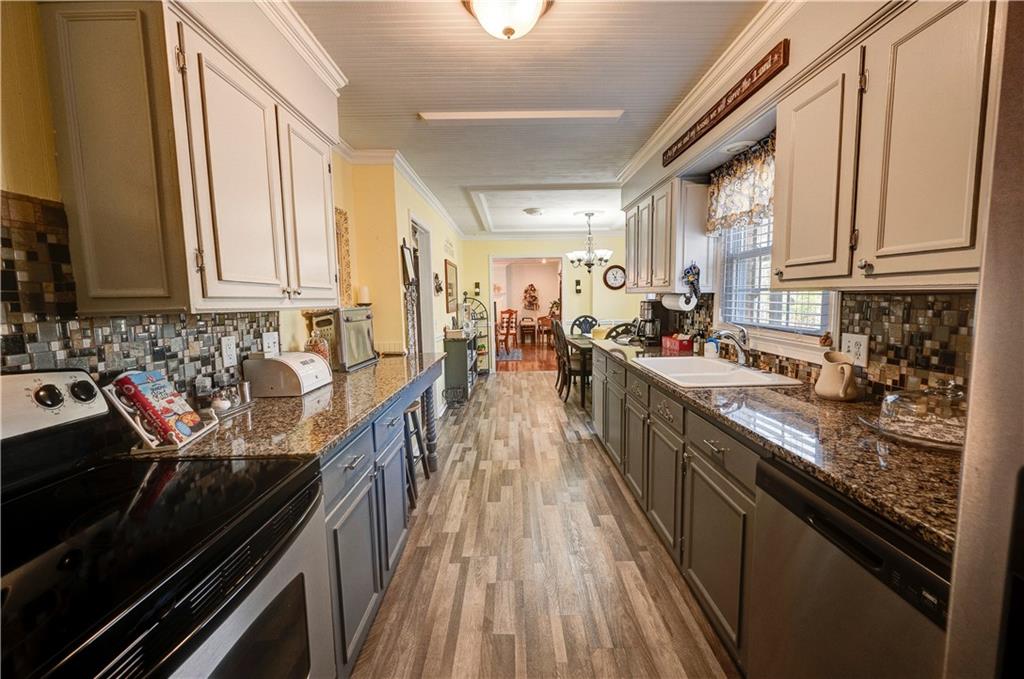 651 Camelot Circle Northwest Calhoun, GA 30701 - Photo 23 of 56 a kitchen with stainless steel appliances a sink stove and cabinets