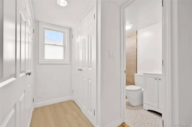 a bathroom with a granite countertop toilet a sink and a mirror
