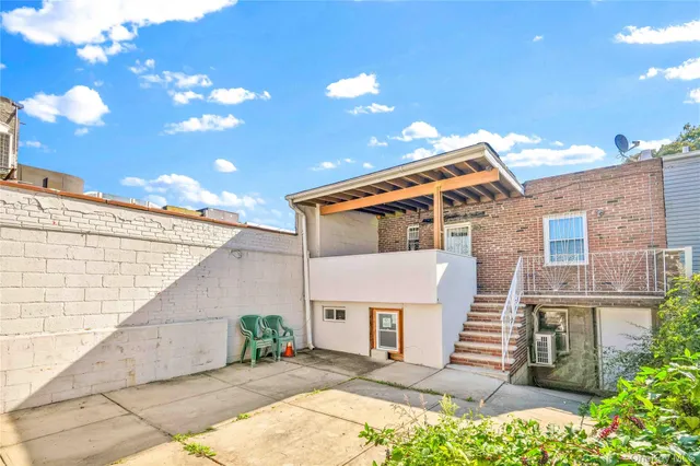 a backyard of a house with potted plants and large tree
