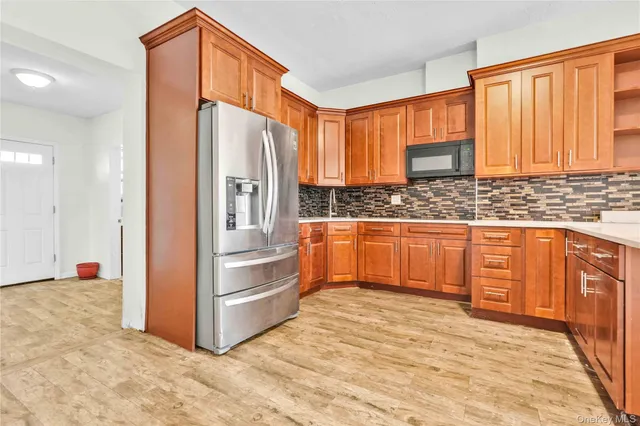 a kitchen with stainless steel appliances a refrigerator and wooden cabinets