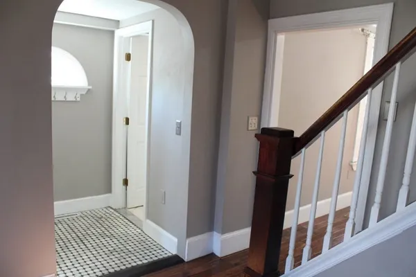 a view of a hallway with wooden floor and staircase