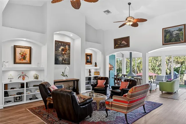 a living room with furniture potted plant kitchen view and a window