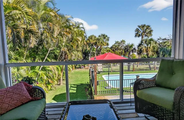 a living room with furniture a lamp and a floor to ceiling window