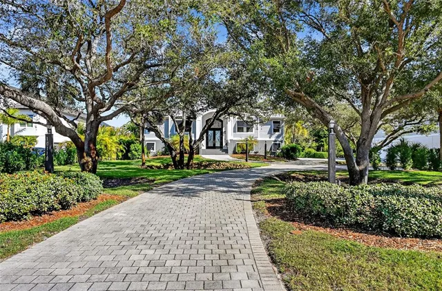 a front view of a building with trees and flowers