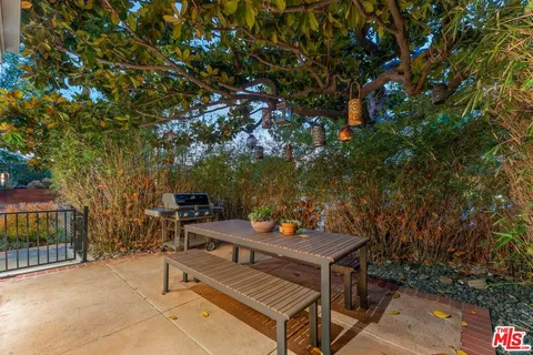 a view of backyard with a table and chairs and potted plants