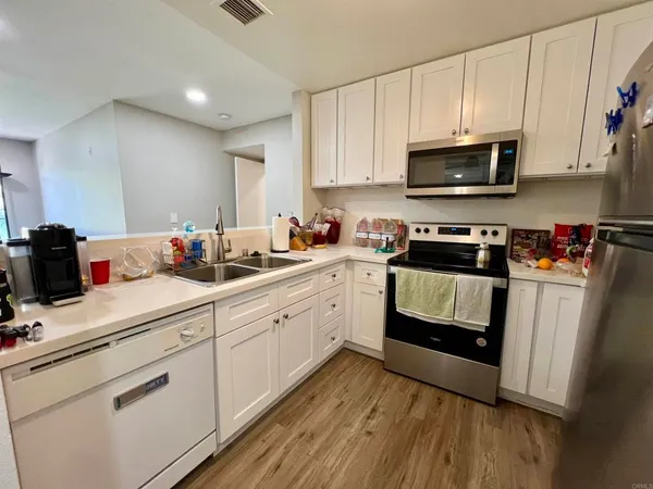 a kitchen with white cabinets stainless steel appliances and sink