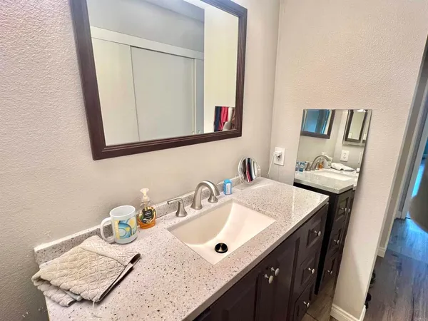 a bathroom with a granite countertop sink and a mirror