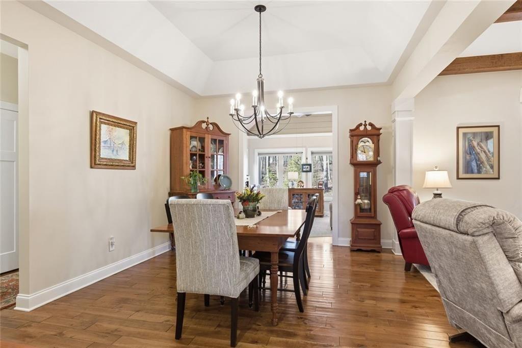 7671 Fern Lane Lula, GA 30554 - Photo 13 of 67 a dining room with furniture a chandelier and wooden floor