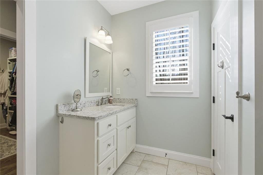 7671 Fern Lane Lula, GA 30554 - Photo 29 of 67 a bathroom with a granite countertop sink a mirror and a shower