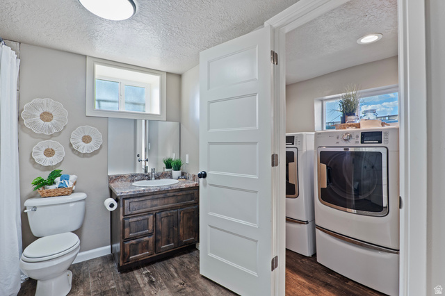 115 East 1600th Street North Santaquin, UT 84655 - Photo 17 of 52 Full bathroom featuring a wood-finish vanity with a stone-look countertop, a white toilet, and wood-finish flooring