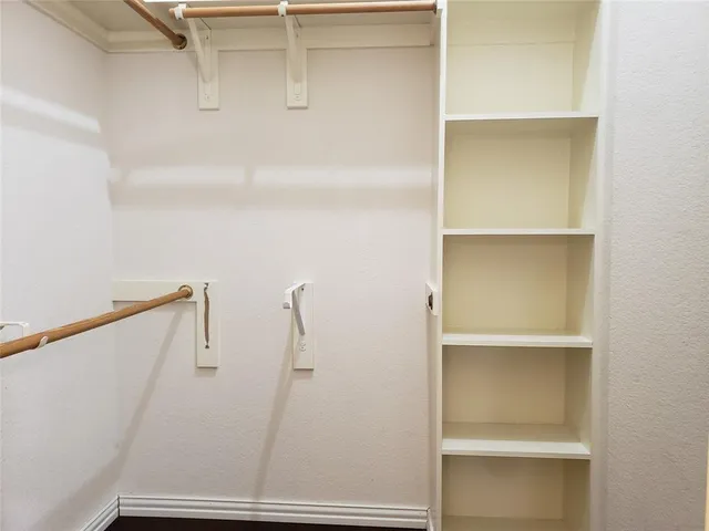 a view of walk in closet with empty racks