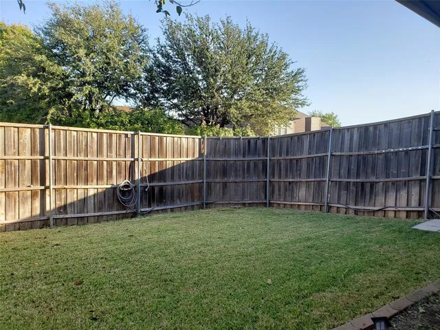 a view of a backyard with a small cabin and wooden fence