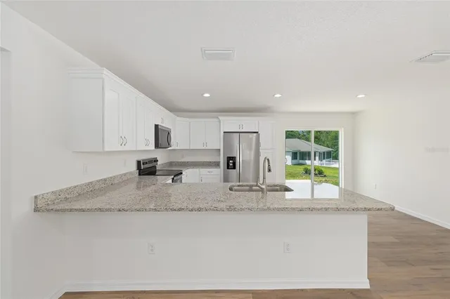 a kitchen with granite countertop kitchen island a counter top space a sink and cabinets