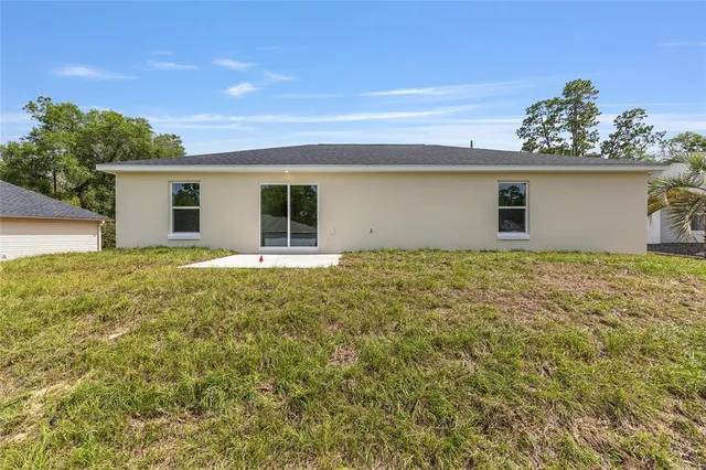 a view of a house with a yard and potted plants