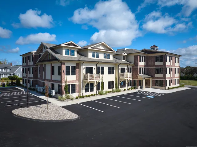 a front view of a building with street view and trees