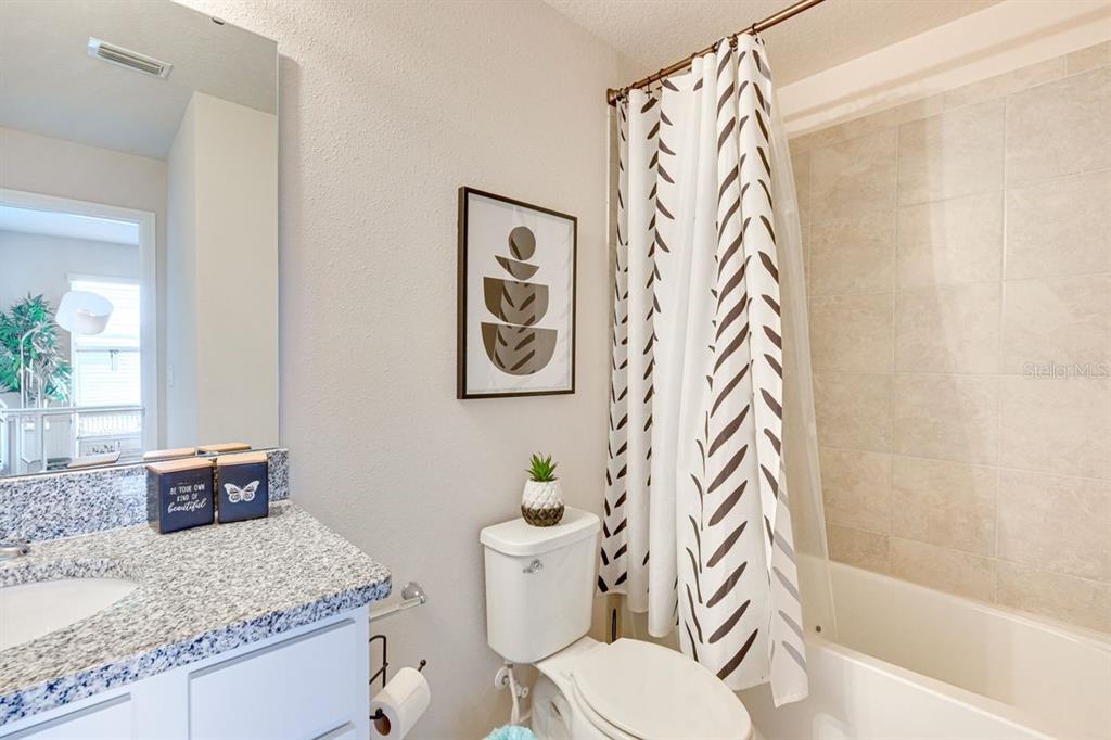 5443 Elmview Crossing Wesley Chapel, FL 33545 - Photo 23 of 41 a white toilet sitting next to a bathroom sink and tub