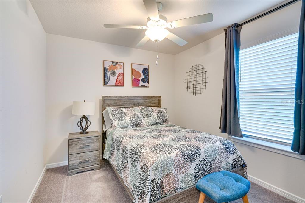 5443 Elmview Crossing Wesley Chapel, FL 33545 - Photo 24 of 41 a bedroom with a bed and a chandelier