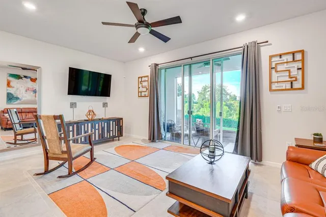 a living room with furniture kitchen view and a wooden floor