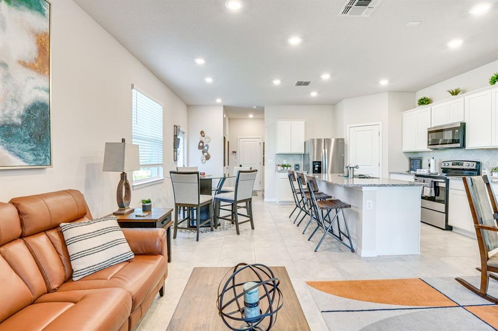 5443 Elmview Crossing Wesley Chapel, FL 33545 - Photo 9 of 41 a living room with furniture kitchen view and a wooden floor