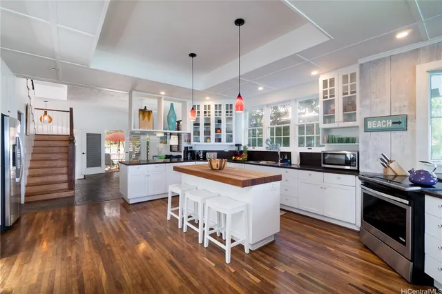 a kitchen with a sink stove and wooden floor