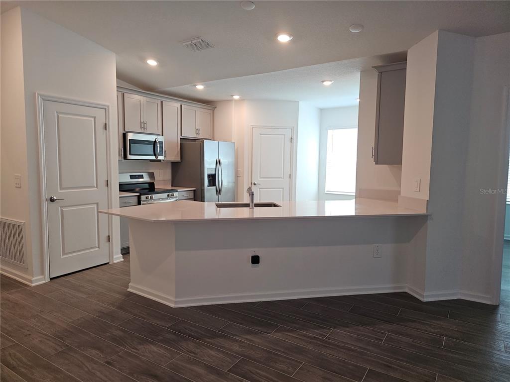 2629 Runners Circle Clermont, FL 34714 - Photo 3 of 22 a kitchen with kitchen island white cabinets and refrigerator