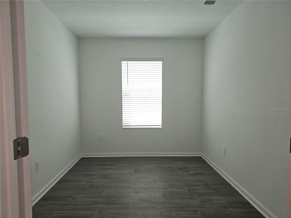 2629 Runners Circle Clermont, FL 34714 - Photo 6 of 22 an empty room with wooden floor and windows