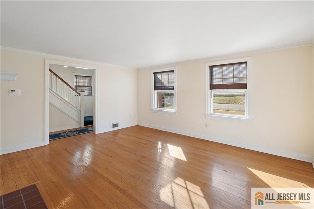 311 Ashland Road Middlesex, NJ 08846 - Photo 5 of 23 a view of an empty room with wooden floor and a window