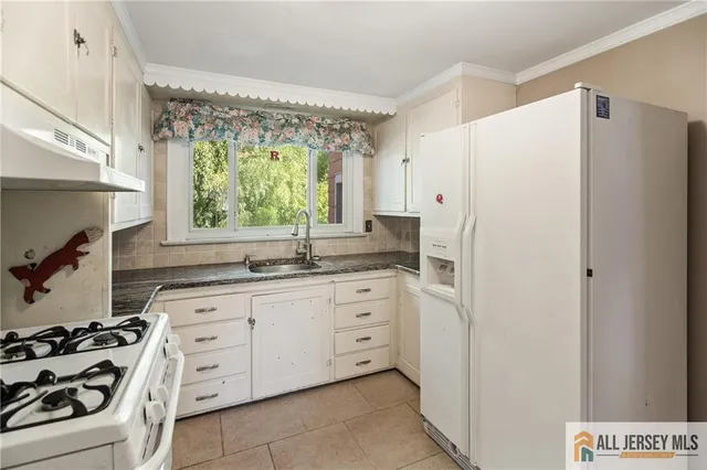 a kitchen with white cabinets and white appliances