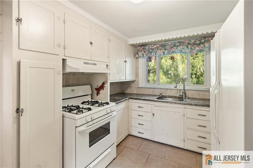 311 Ashland Road Middlesex, NJ 08846 - Photo 9 of 23 a kitchen with granite countertop white cabinets and white appliances