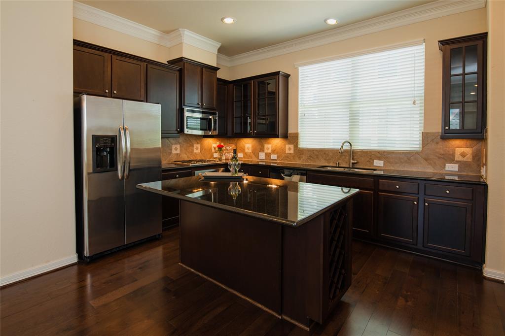 Open kitchen features ss appliances, functionary island with wine rack, cabinets and drawers, 42" floating cabinets, gas range, under mount sink, granite counter tops and beautiful hard wood floor.