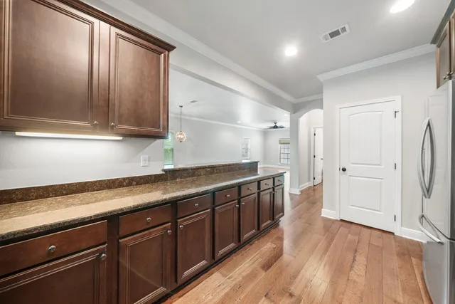 a large kitchen with stainless steel appliances granite countertop a refrigerator and a sink