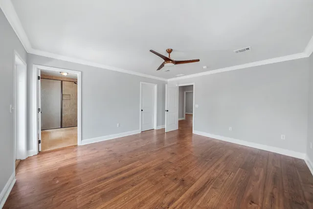 a view of a livingroom with wooden floor and a ceiling fan