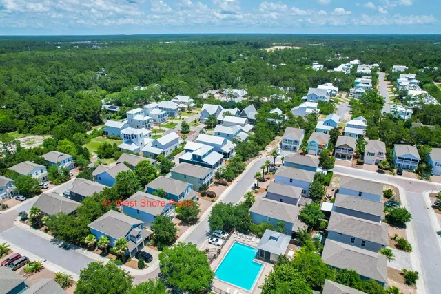 an aerial view of residential houses with outdoor space and trees