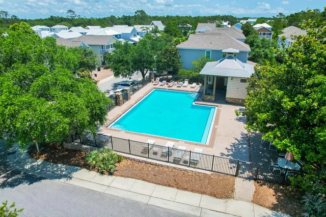 an aerial view of a house with table and chairs under an umbrella